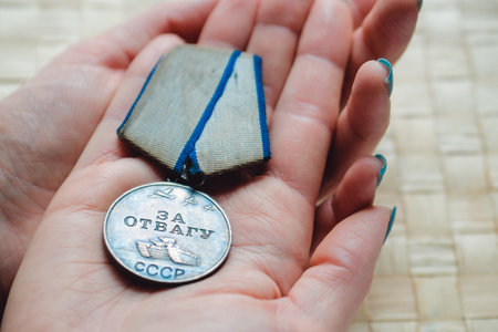 Close-up of vintage medal for honor on womans hand. Concept of patriotismのeditorial素材