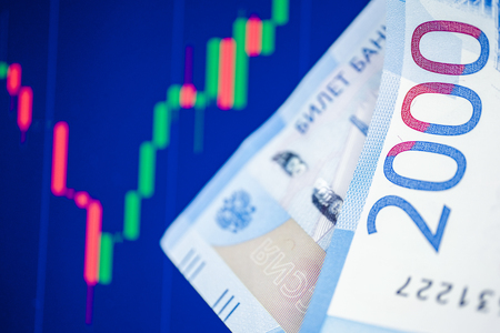 The concept of the fall and the growth of the ruble exchange rate. Two thousand rubles on the background of the blue chart.の写真素材