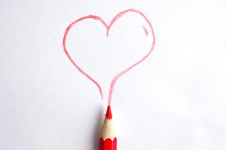 The concept of love for creativity. Painted heart by red pencil on a white background.の写真素材