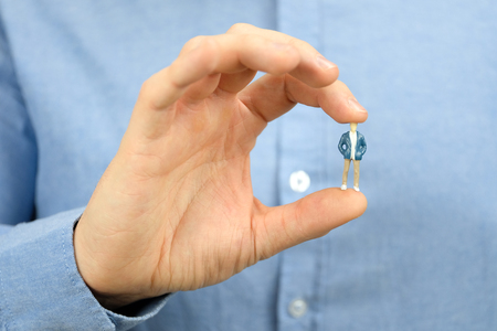 The concept of recruiting an employee to work. A man in a blue shirt is holding a small male model.の写真素材