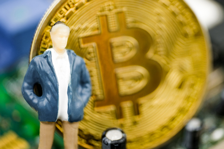 The concept of a successful crypto trader. Model trader on the background of a bitcoin coin on the chip.の写真素材