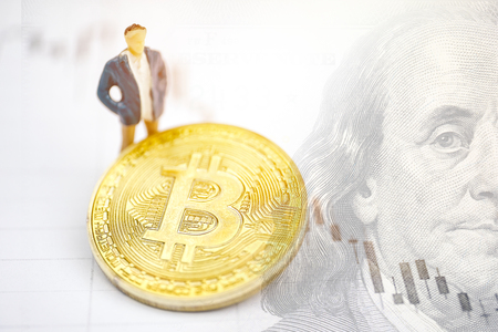 The concept of a successful crypto trader. Model trader on the background of a bitcoin coin on the chip with dollar.の写真素材