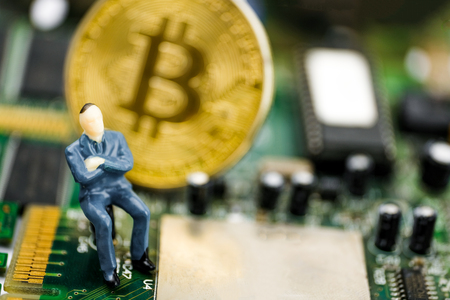 The seller of cryptocurrency mining equipment concept. The model of the seller on the background of a bitcoin coin on a chip.の写真素材