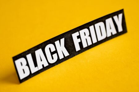 Black Friday sticker on a yellow background. Close up.の写真素材