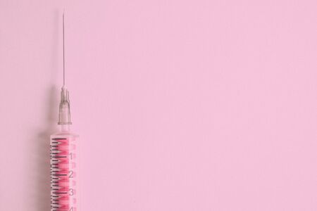 Cocktail from drugs of injections and tablets at one time. Syringe with pills against pink background. Place for text.の写真素材