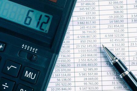 Pen with calculator on paper background with totals.の写真素材