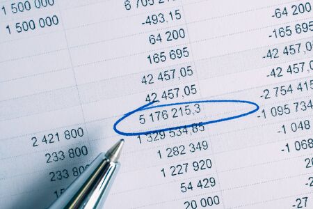 Pen on paper background with circled totals. . Concept financial reports. Toned. Verticalの写真素材