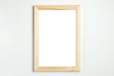 Rectangular wooden vertical frame on a white wooden background. Moke up. Top view. Copy space.