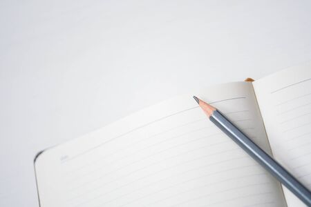 Notebook with pencil on white wooden table. Top view.の写真素材