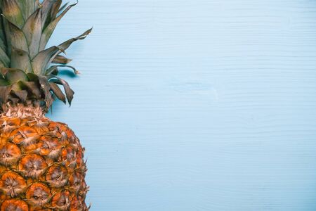 Ripe pineapple left side on a blue wooden table. Copy space. top view. Close up.の写真素材