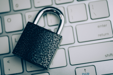 Concept of reliable protection. The lock on the white keyboard. Toned and close up.の写真素材