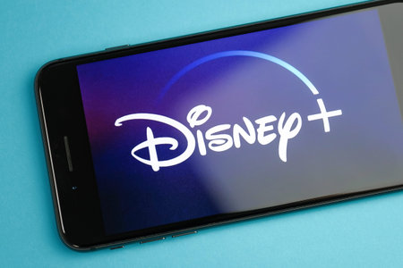 RUSSIA, ST.PETERSBURG, April 16, 2019: Image Disney plus on a smartphone on a blue background. Close...