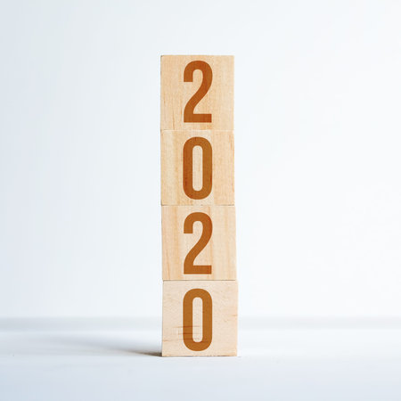 Numbers symbolizing the new year 2020 on wooden cubes standing on top of each other on white...