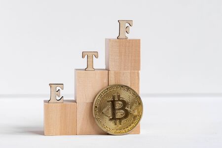 Etf letters made of wood next to a bitcoin coin. Cryptocurrency investment growth concept. Close up.の写真素材