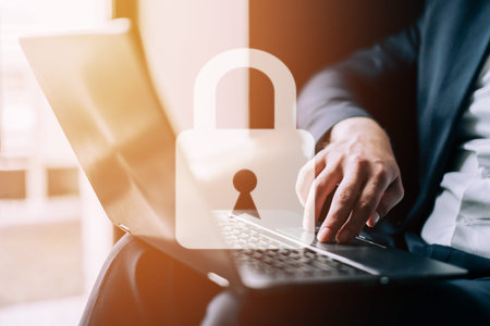 Data Protection Concept. Padlock on the background of a man working on a laptop.