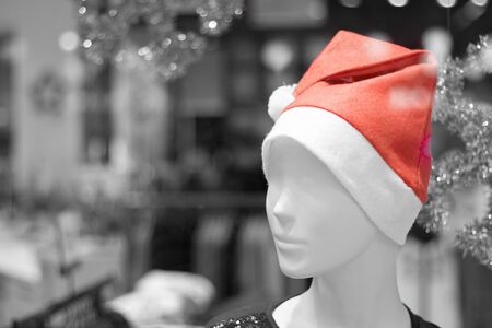 A mannequin on a display case with a red cap on his head. The concept of the New Year's sale. Close up.の写真素材
