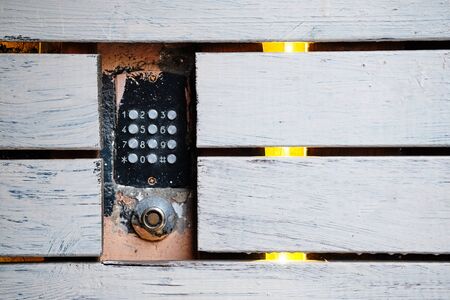 An old intercom with a magnetic key space mounted in the facade. There are wooden white boards around. Close up.の写真素材