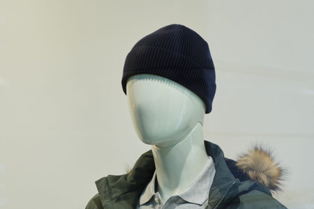 a mannequin dressed in winter clothes on a white background. Close up.