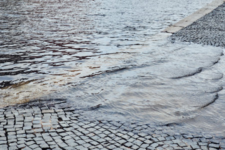 Water on the waterfront, road. The concept of the flood. Close up.