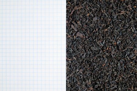 Clean sheet in a cage on background of black tea with copy space. Concept of tea shop, notes during tea party.の写真素材
