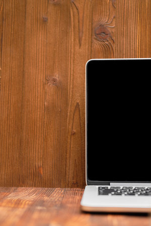 Laptop on a wooden background. A place to copy space. Close up.