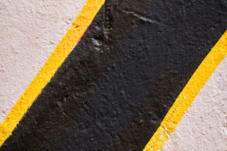 Abstract texture of plaster beige, black with a yellow stripe. Close up.