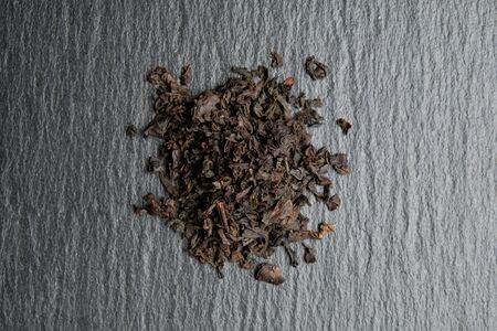 Dry black tea on a slate. Close up.の写真素材