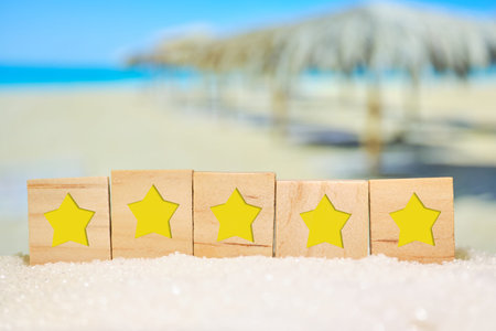 Beautiful blurred view of the beach with wooden cubes with stars. Concept of rating, evaluation of...