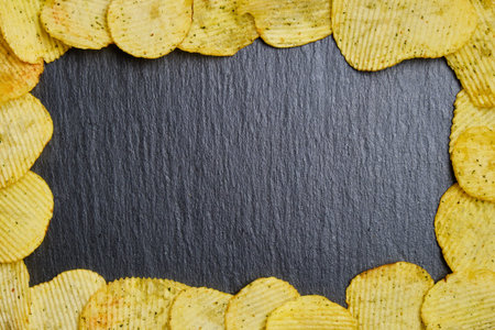Chips are framed on a slate dish. Top view. Copy space. Close up.の写真素材
