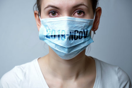 Girl with sick red eyes with a protective mask wearing a coronavirus 2019-NCOV. The concept of the...