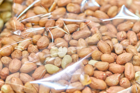 Packing from a transparent bag with Brazil nuts. Close up.