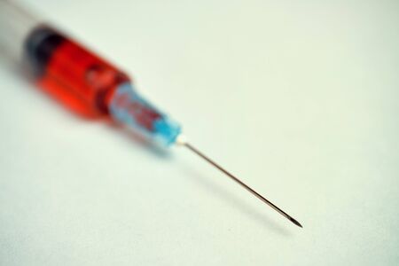 Syringe with red substance. Toned Close up.の写真素材