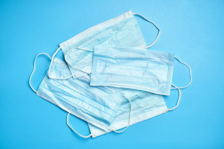 Several medical masks on a blue background. top view