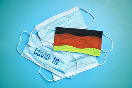 Medical masks on a cinema background. Abstract germany flag on fabric and inscription coronovirus virus COVID-19. Close up.の写真素材