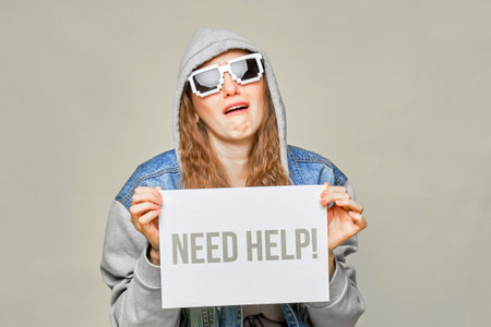 Stylish Caucasian girl in jeans and glasses 8 bit on a yellow background. Holding a piece of white...