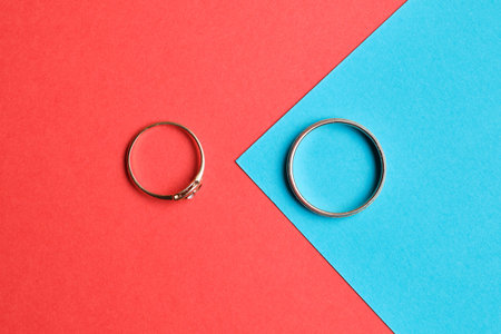 wedding rings on blue and red paper. Top view. Close up.