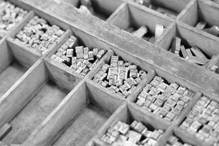 Old metal letters for printing black and white photo. Close up. Noise.