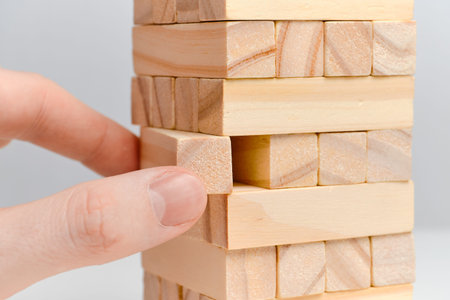 Big date moderation concept. Hand holds wooden blocks on a white background. Close up.
