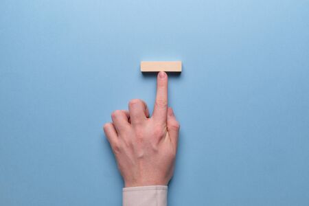 Concept influencer in business. Hand holds wooden blocks on a blue background. Close up.の写真素材