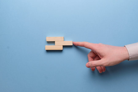Innovation Integration Concept. Hand holds wooden blocks on a blue background. Close up.