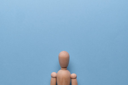 Wooden mannequin bust for copy space on a blue background. Close up.
