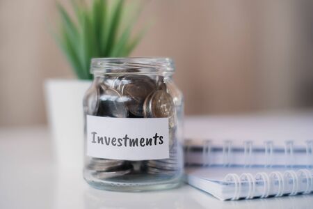 The concept of accumulating money for investments - a glass jar with coins. Close up.