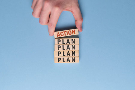 Activation plan concept - hand holds wooden block with the inscription on a blue background. Close...