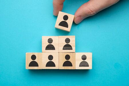 Leadership concept - wooden blocks with abstract people on a blue background. Close up.の写真素材