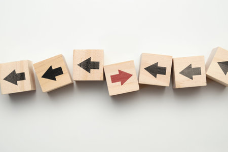 Concept of think differently - wooden cubes with arrows. Close up.