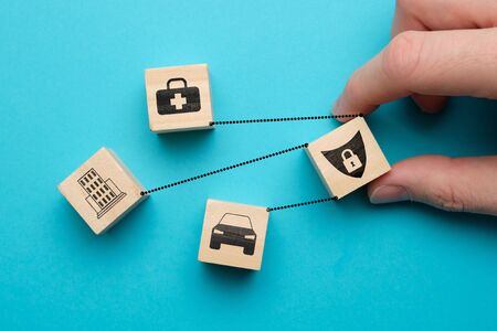 Car, health, real estate insurance concept - abstract signs on wooden cubes with a blue background. Close up.の写真素材