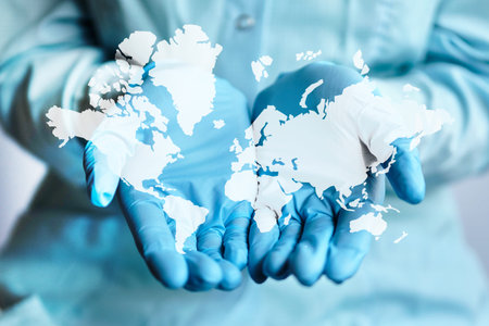 Abstract image of the world map on the hands of the doctor in medical gloves. Close up.