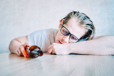 A heavily drunk man lies on the table. Close up.の写真素材