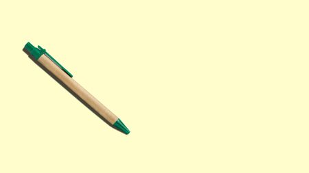 Casual ballpoint pen against yellow background with copy space. Close up.の写真素材