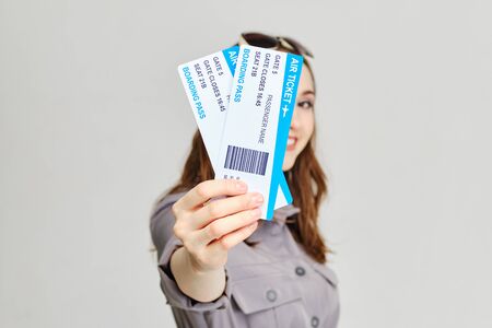 Girl holds forward plane tickets with a smile. Close up.の写真素材